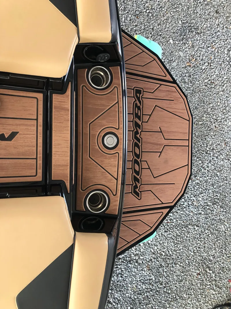 Slide: The Image of 2023 Moomba Makai boat deck with wood finish and logo detailing. - 24