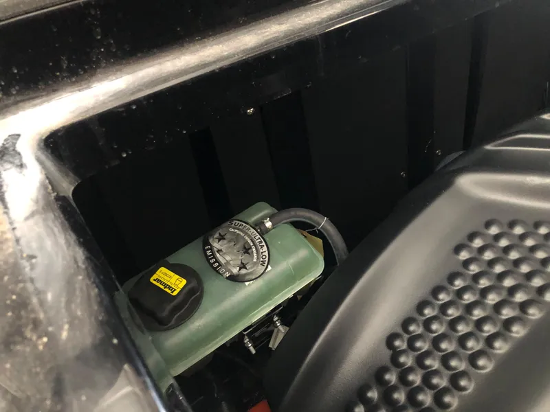 Slide: The Image of Close-up of 2023 Moomba Makai engine compartment, featuring a fluid reservoir and textured engine cover. - 31