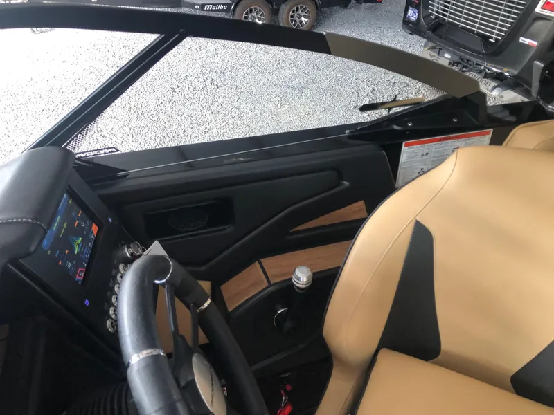 Slide: The Image of 2023 Moomba Makai boat interior with tan seats and modern dashboard. - 39