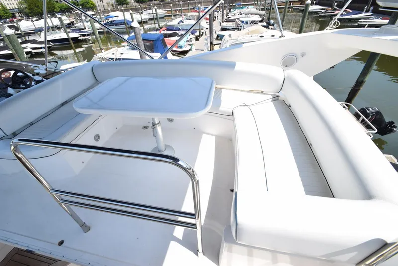 Slide: The Image of 2005 Sunseeker Manhattan 50 yacht with white seating and table on deck. - 17
