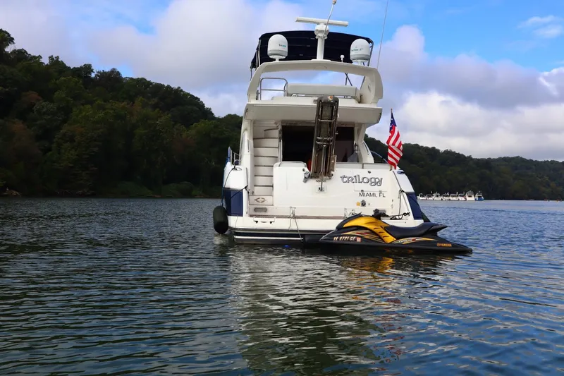 Slide: The Image of 2005 Sunseeker Manhattan 50 yacht with jet ski on calm water. - 2