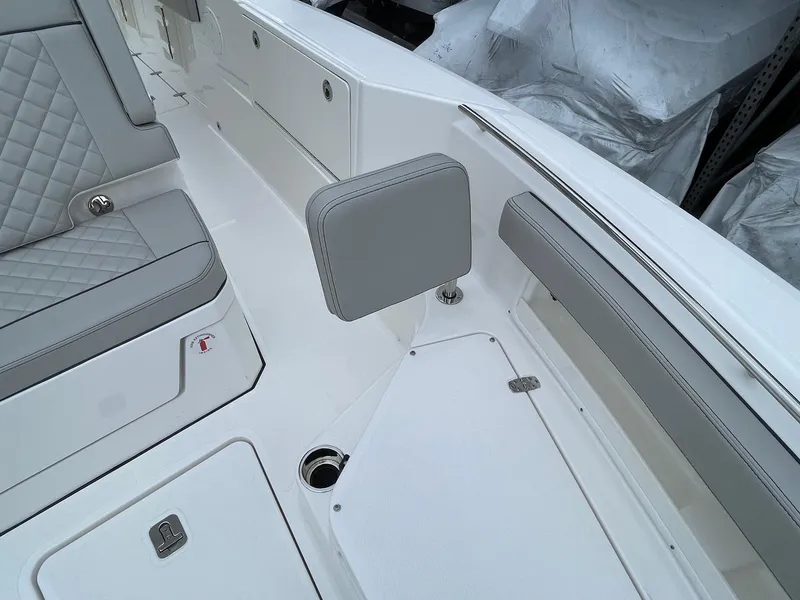 Slide: The Image of 2024 Pursuit S 248 Sport boat interior with gray cushioned seating and storage compartments. - 14