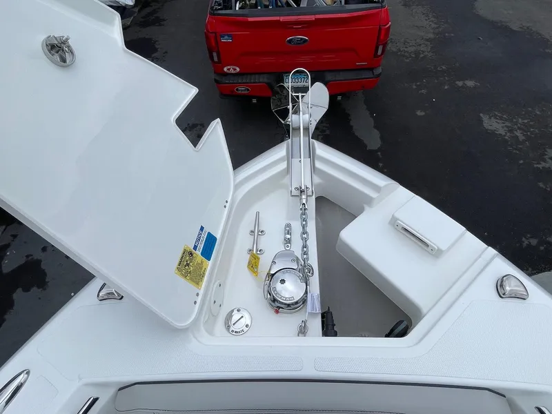 Slide: The Image of 2024 Pursuit S 248 Sport boat anchor compartment with a red truck in the background. - 16