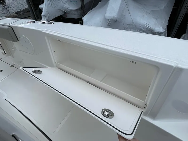 Slide: The Image of 2024 Pursuit S 248 Sport boat storage compartment with open lid. - 18
