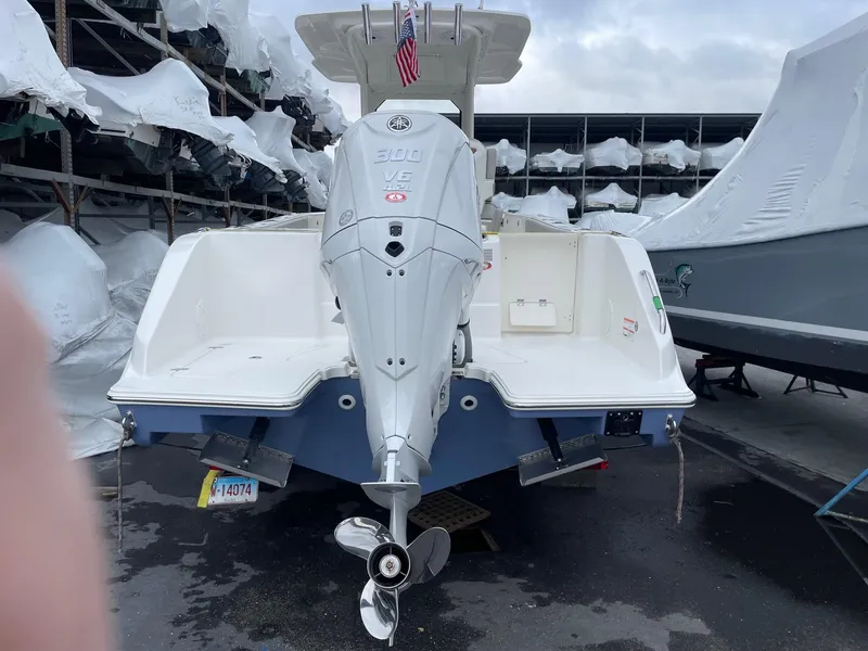 Slide: The Image of 2024 Pursuit S 248 Sport boat with Yamaha 300 outboard engine, docked in a marina. - 2