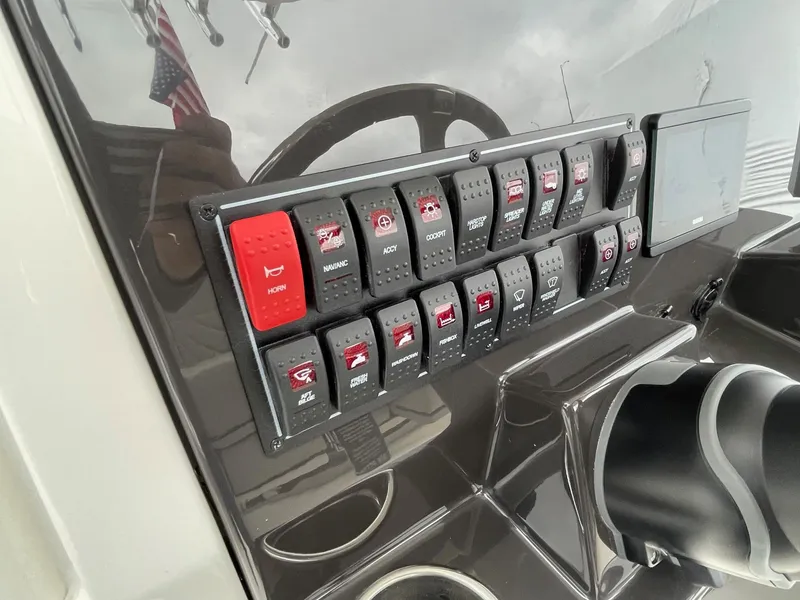 Slide: The Image of Control panel of the 2024 Pursuit S 248 Sport boat with various switches and buttons. - 20