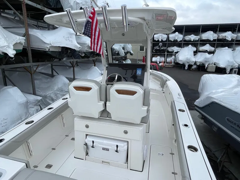 Slide: The Image of 2024 Pursuit S 248 Sport boat interior with American flag, docked in marina. - 4