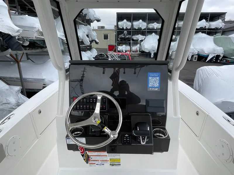 Slide: The Image of 2024 Pursuit S 248 Sport boat helm with steering wheel and control panel. - 5
