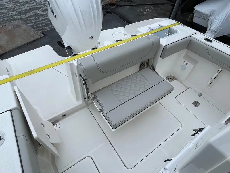Slide: The Image of 2024 Pursuit S 248 Sport boat interior with foldable seating and white upholstery. - 7