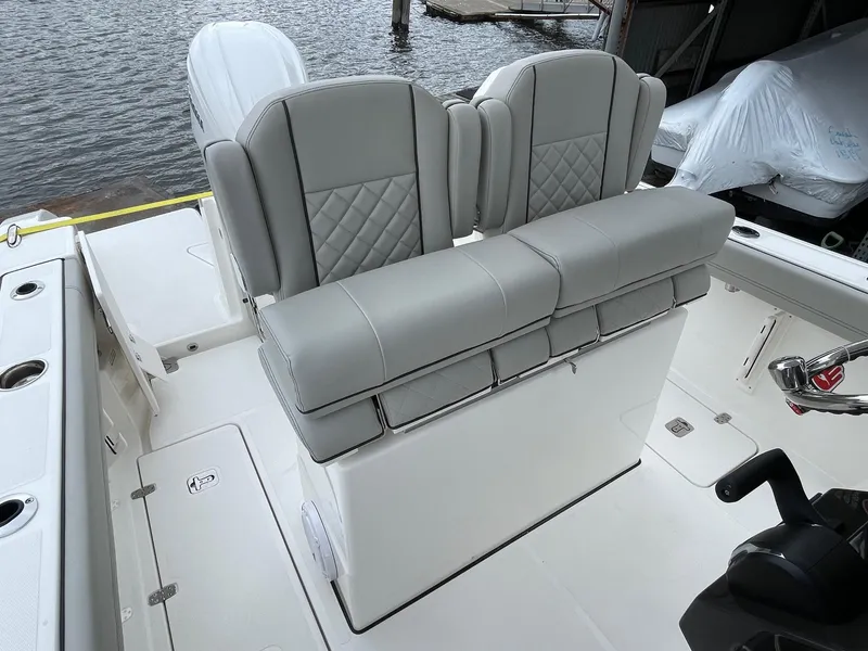 Slide: The Image of 2024 Pursuit S 248 Sport boat with dual cushioned seats and water backdrop. - 8