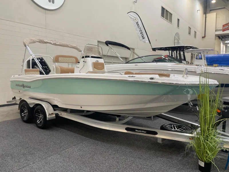 The Image of 2024 NauticStar 211 Hybrid boat on display in an indoor showroom. - 0