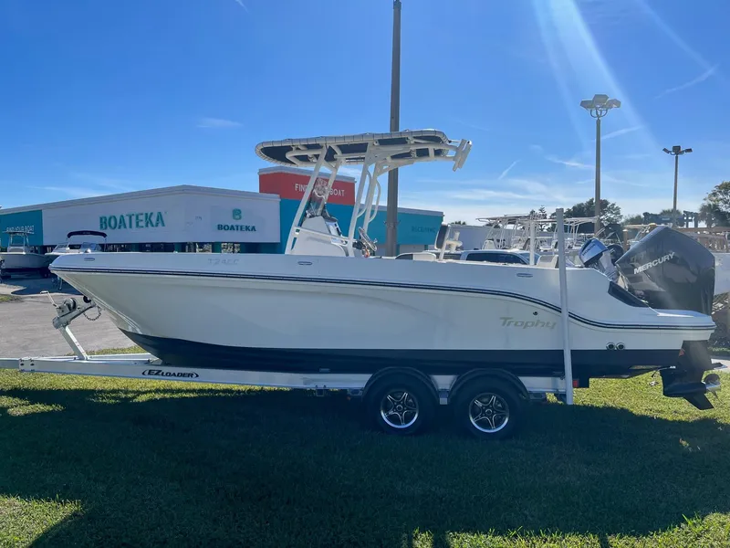 The Image of 2023 Bayliner Trophy T24 boat on trailer at dealership, sunny day. - 0