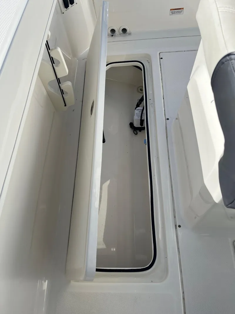 Slide: The Image of 2023 Bayliner Trophy T24 boat storage compartment with open lid. - 13