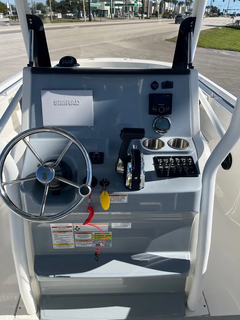 Slide: The Image of 2023 Bayliner Trophy T24 helm with steering wheel and control panel. - 2