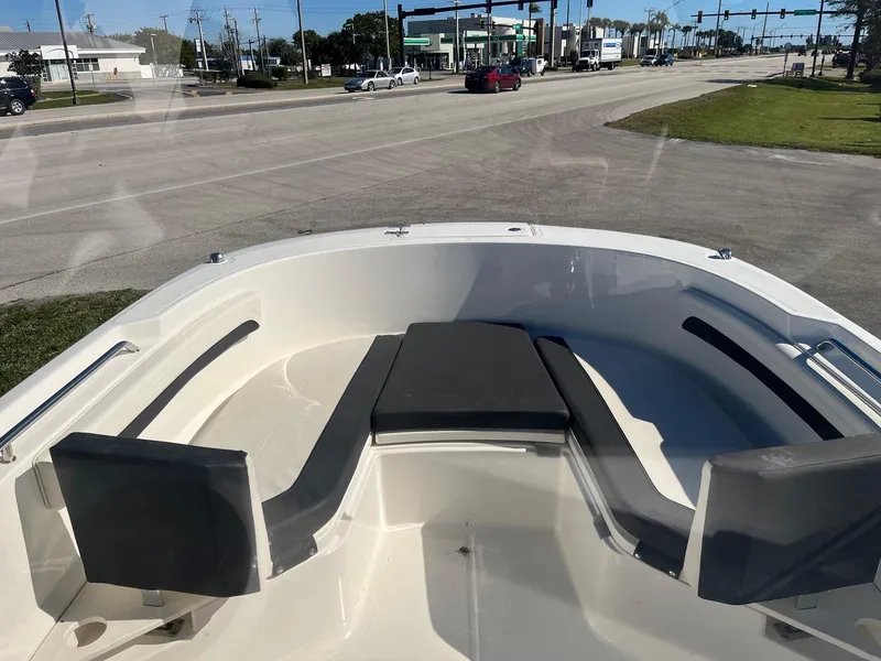 Slide: The Image of 2023 Bayliner Trophy T24 boat interior with seating, parked near a road. - 9