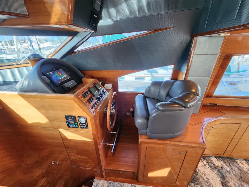 Slide: The Image of 2007 Ocean Alexander Veloce helm with leather seat, wooden dashboard, and modern navigation controls. - 11