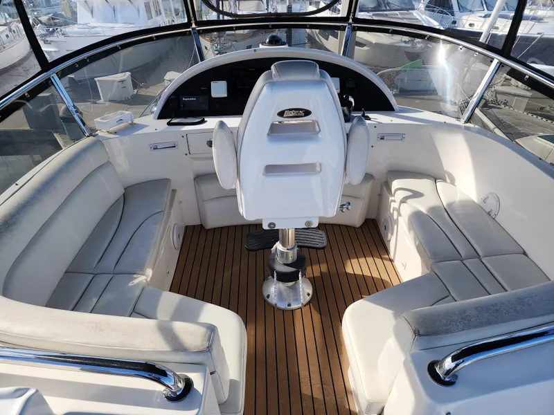 Slide: The Image of 2007 Ocean Alexander Veloce yacht helm with white seating and wooden deck. - 30