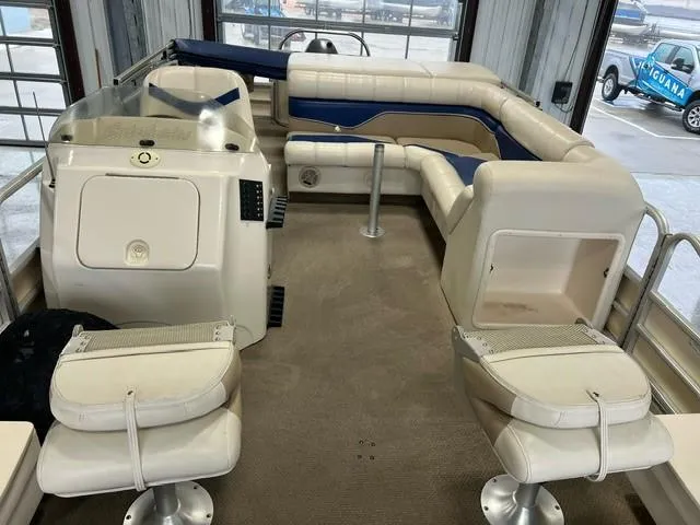 Slide: The Image of 2004 Godfrey F20 pontoon boat interior with beige and blue seating. - 6