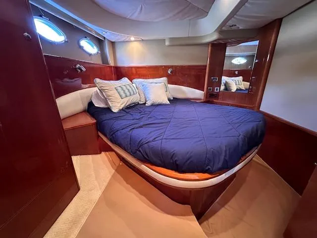 Slide: The Image of Luxurious cabin interior of 2006 Princess 58v yacht with cozy bed and elegant wood finish. - 22