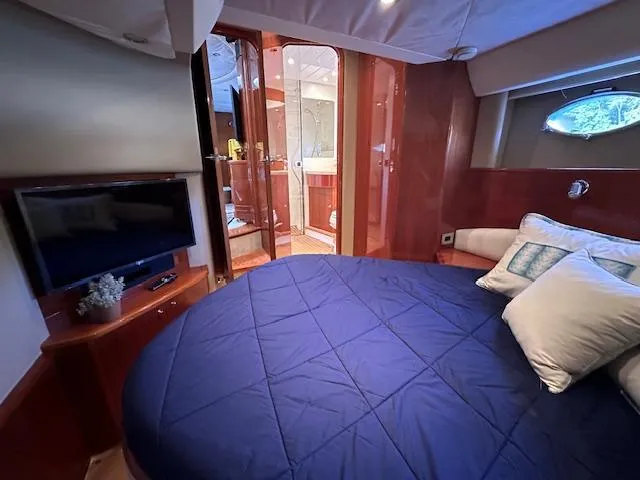 Slide: The Image of Luxurious cabin interior of 2006 Princess 58v yacht with cozy bedding and TV. - 23