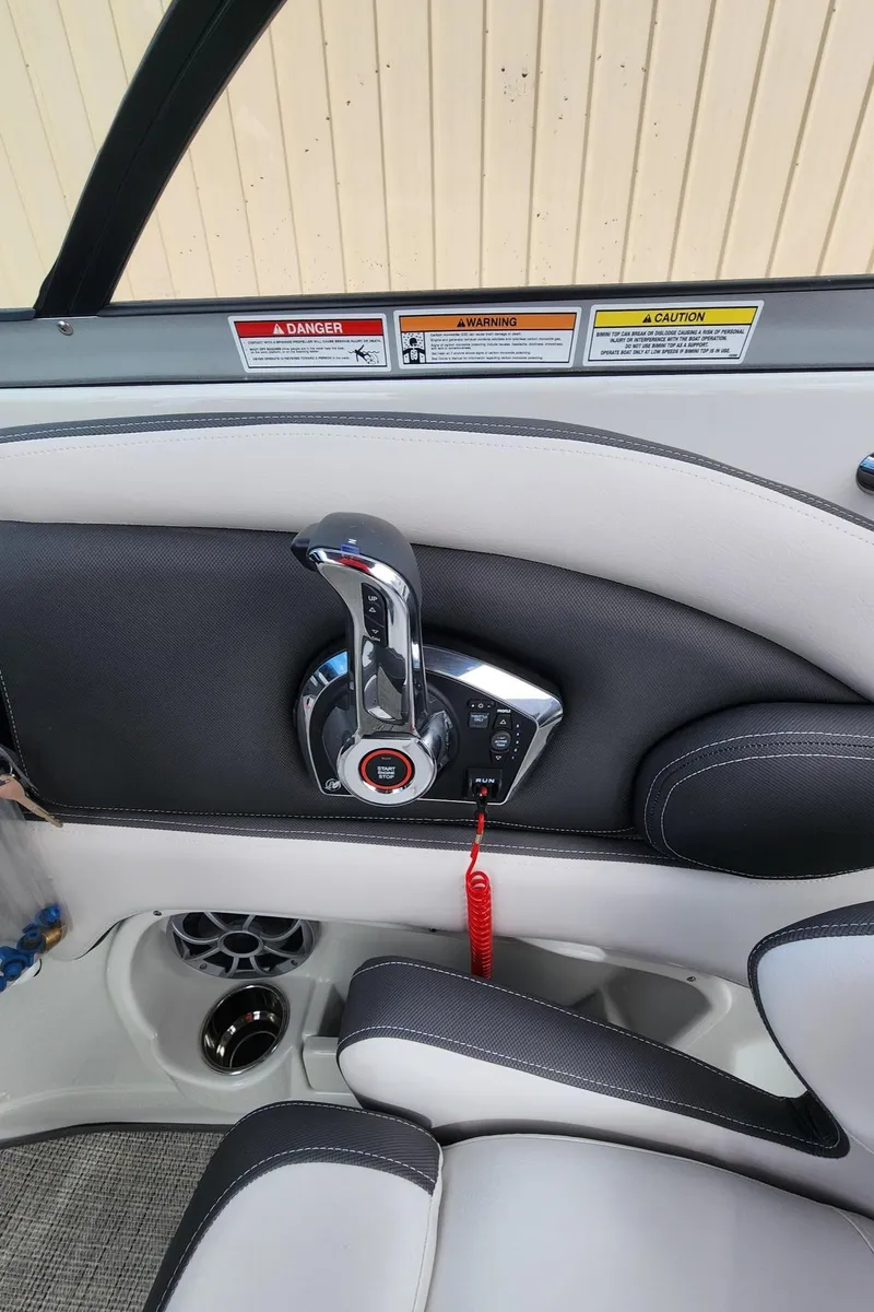 Slide: The Image of 2024 Crownline E235 boat interior with control panel and throttle. - 11