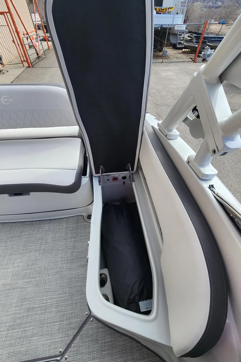 Slide: The Image of 2024 Crownline E235 boat with open storage compartment. - 12