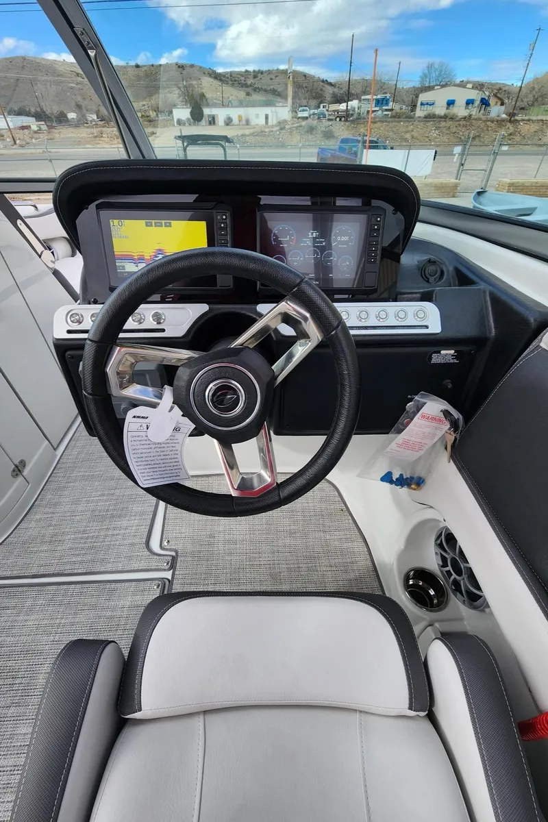 Slide: The Image of 2024 Crownline E235 boat cockpit with modern steering wheel and dual display screens. - 6