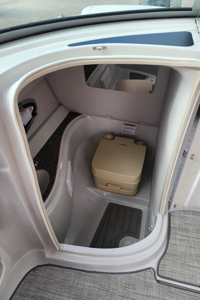 Slide: The Image of 2024 Crownline E235 boat interior with compact toilet. - 8