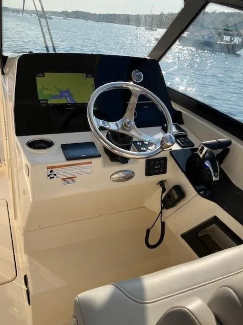 Slide: The Image of 2022 Scout 277 Dorado boat helm with steering wheel and navigation display. - 8