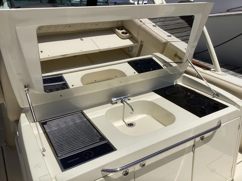 Slide: The Image of 2016 Chris-Craft 34 Catalina boat galley with sink, stove, and storage. - 13
