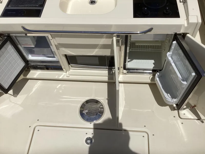 Slide: The Image of 2016 Chris-Craft 34 Catalina boat kitchen area with open fridge and sink. - 17