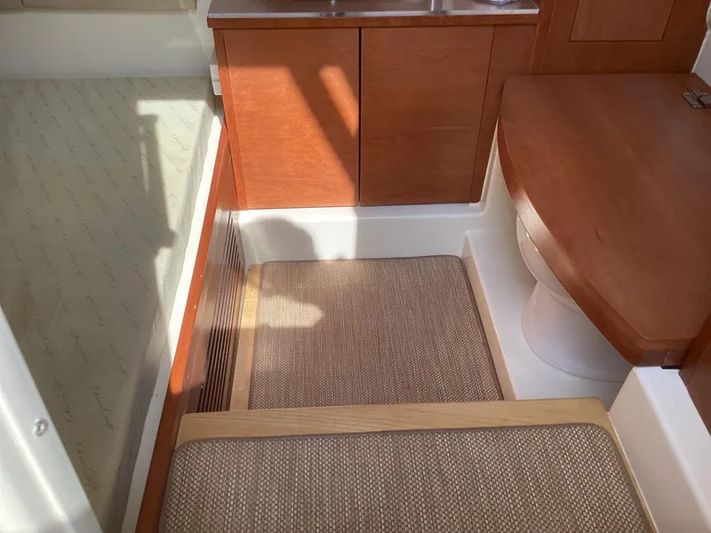 Slide: The Image of Interior of 2016 Chris-Craft 34 Catalina, featuring wooden cabinetry and cushioned seating. - 34