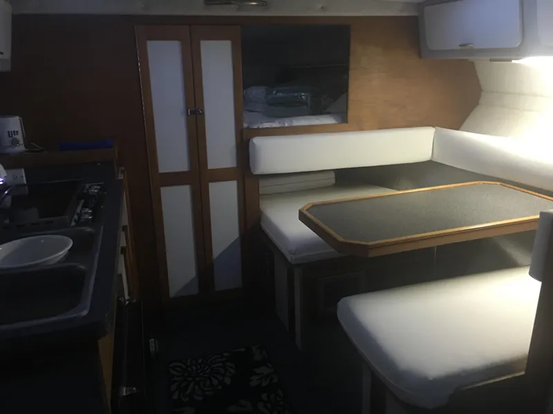 Slide: The Image of Interior of 1989 Cruisers Yachts 3060 Rogue, featuring dining area and kitchenette. - 7
