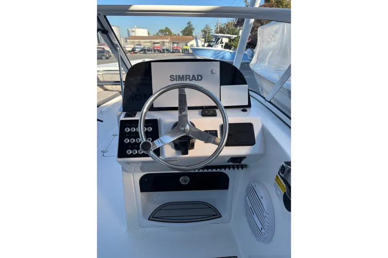 Slide: The Image of 2024 Sea Pro 240 Dual Console boat dashboard with steering wheel and Simrad display. - 4