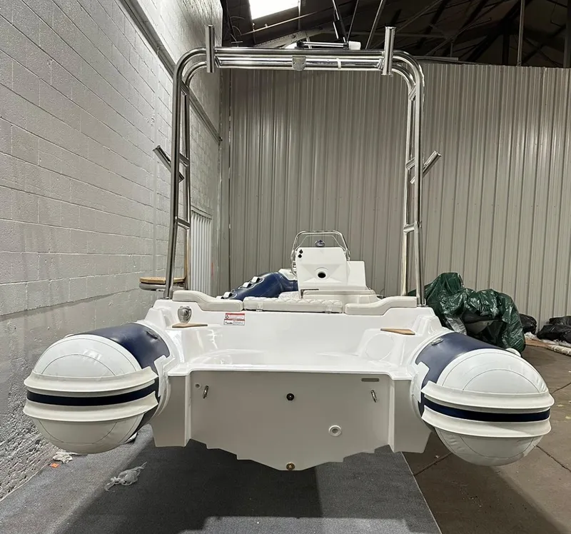 Slide: The Image of 2024 Apex A-18 Deluxe Tender boat in warehouse setting, rear view. - 3