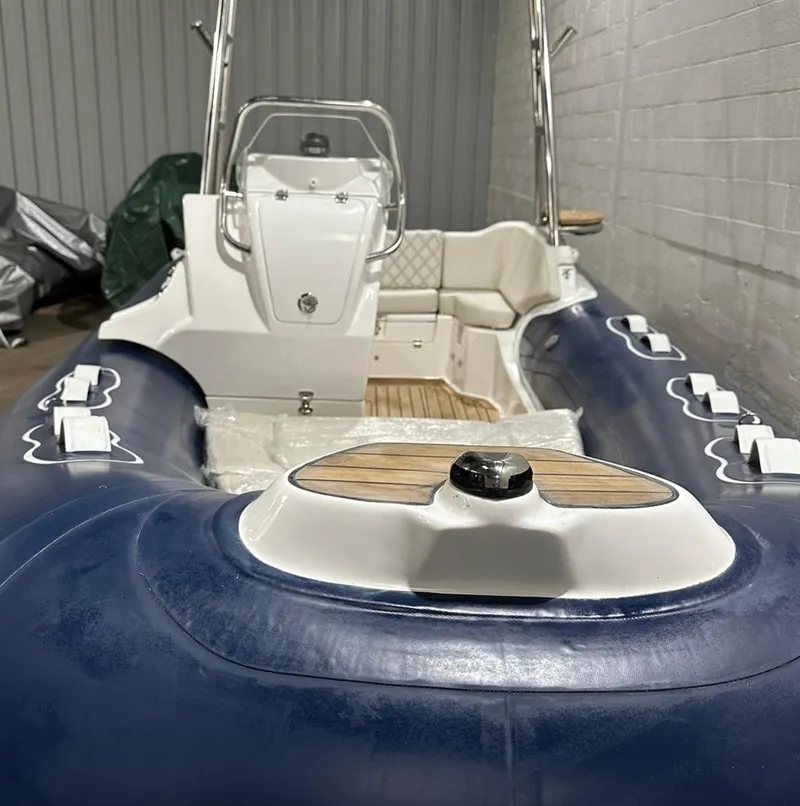 Slide: The Image of 2024 Apex A-18 Deluxe Tender, blue and white design, in a storage facility. - 10