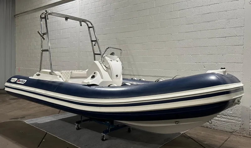 Slide: The Image of 2024 Apex A-18 Deluxe Tender boat in a showroom, featuring sleek design and sturdy construction. - 6