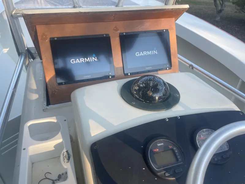 Slide: The Image of Custom Carolina Bandy 26' 2000 boat dashboard with Garmin screens and compass. - 10