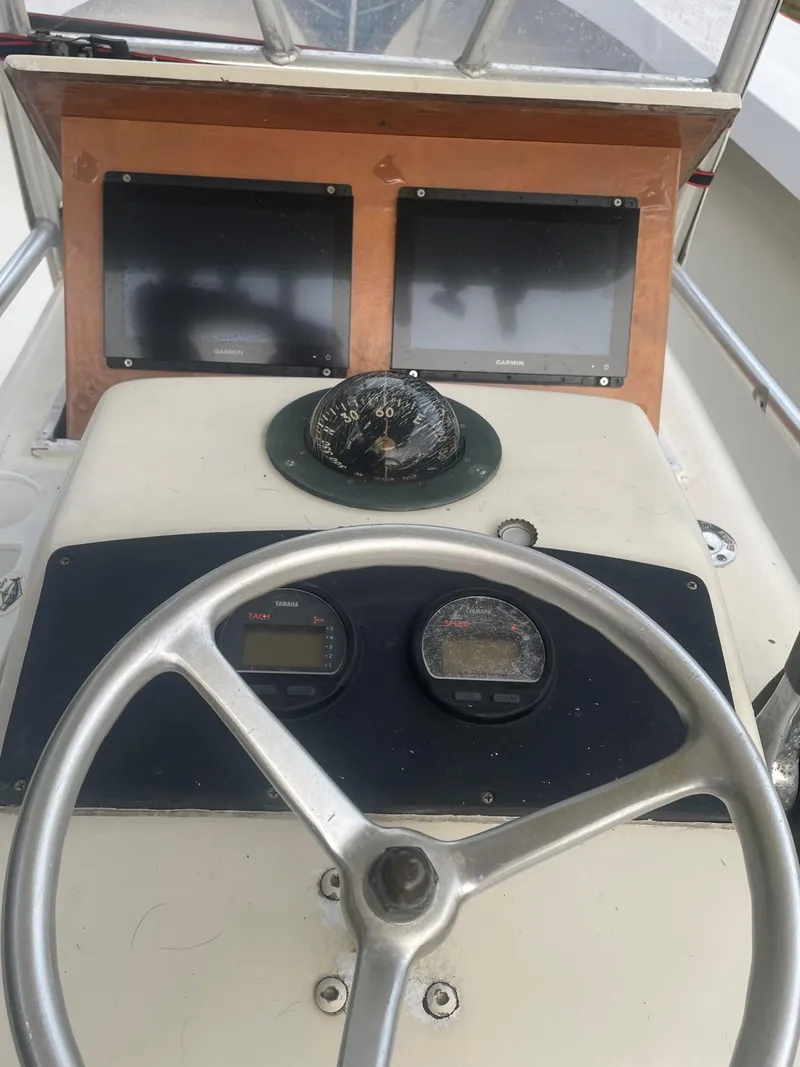 Slide: The Image of Steering console of 2000 Custom Carolina Bandy 26' boat with gauges and compass. - 12