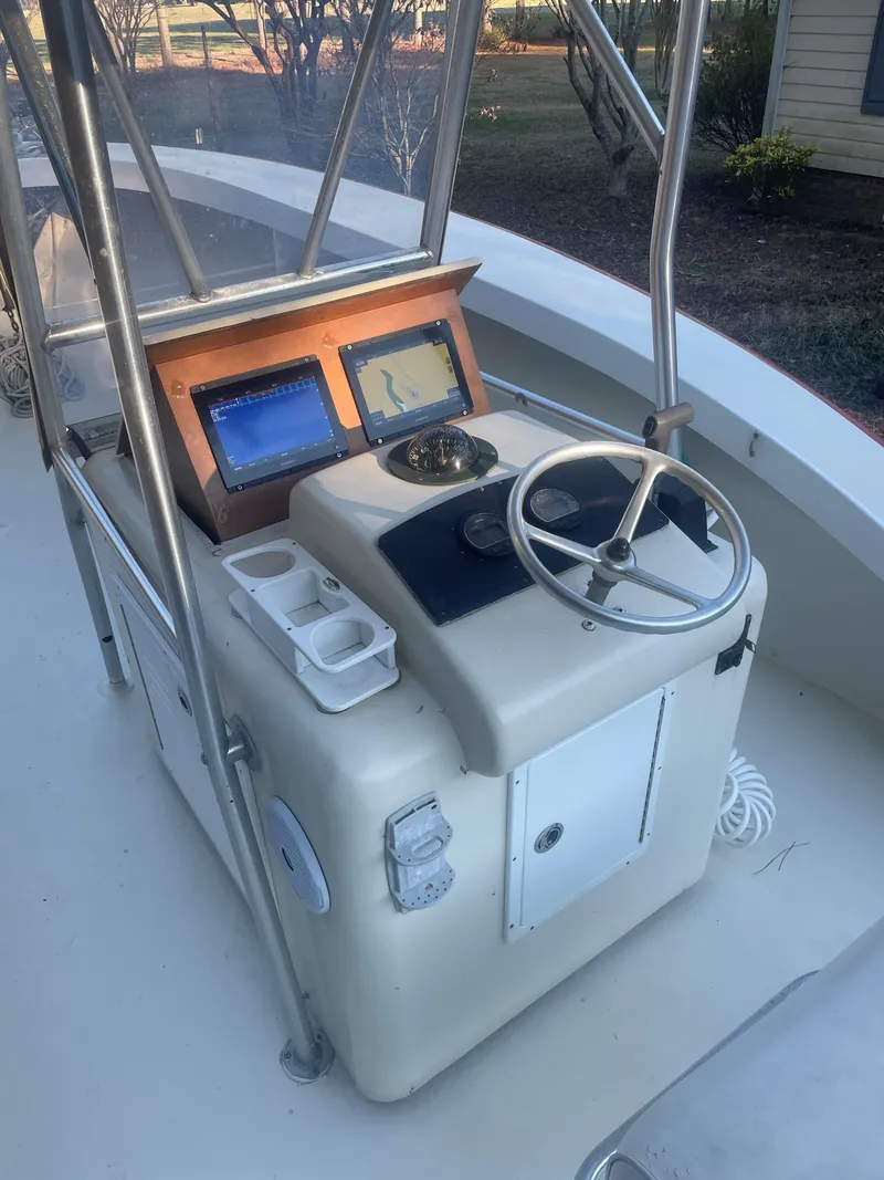 Slide: The Image of Custom Carolina Bandy 26' 2000 boat console with steering wheel and navigation screens. - 9
