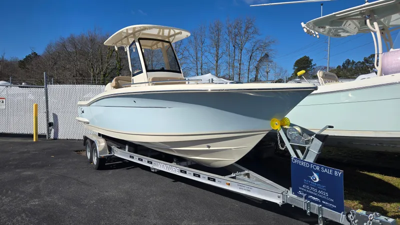Slide: The Image of 2024 Scout 240 XSF boat on trailer, displayed outdoors under clear blue sky. - 12