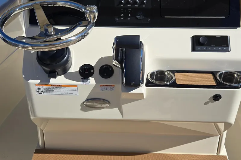 Slide: The Image of 2024 Scout 240 XSF boat dashboard with steering wheel and controls. - 16