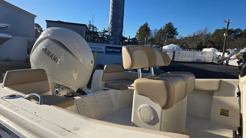 Slide: The Image of 2025 Scout 195 Sportfish boat with Yamaha engine, beige seating, and outdoor marina setting. - 10