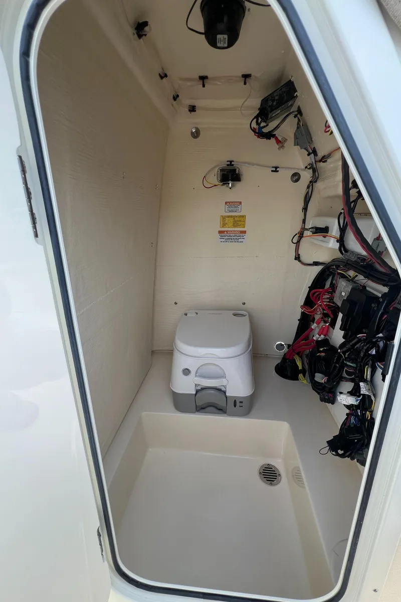 Slide: The Image of Interior of 2025 Scout 195 Sportfish boat with portable toilet and wiring. - 8