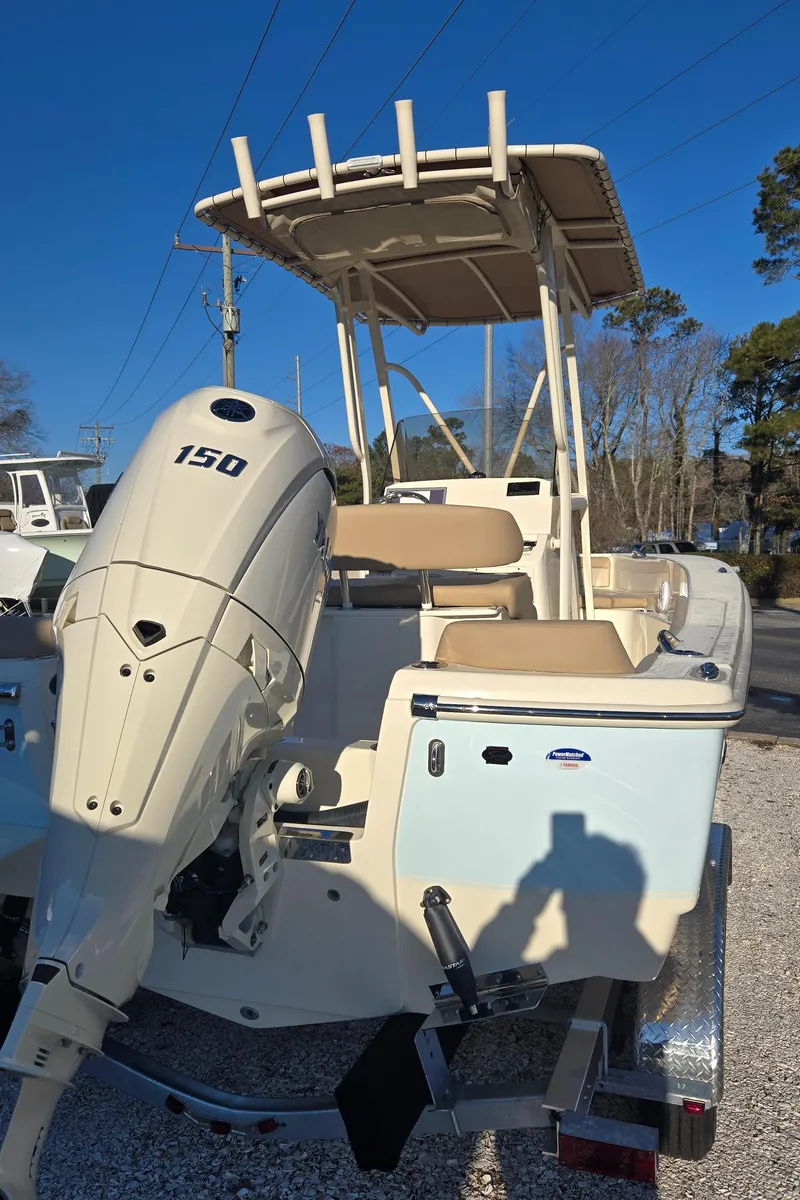 Slide: The Image of 2025 Scout 195 Sportfish boat with 150 HP engine, parked outdoors. - 13