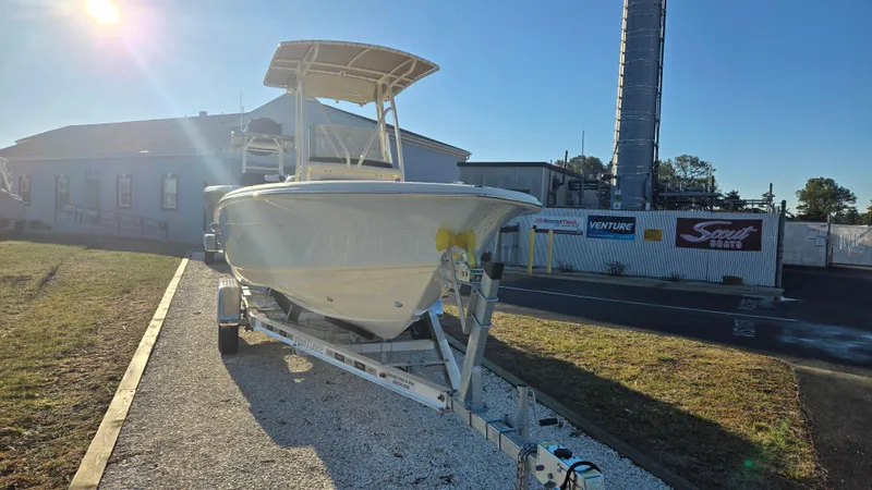 Slide: The Image of 2025 Scout 195 Sportfish boat on trailer, parked outdoors in sunlight. - 3