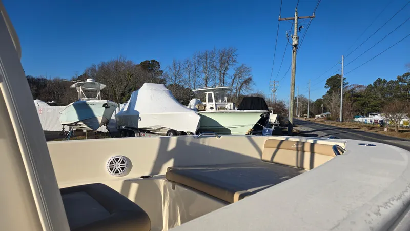 Slide: The Image of 2025 Scout 195 Sportfish boat in storage yard, surrounded by other covered boats. - 5