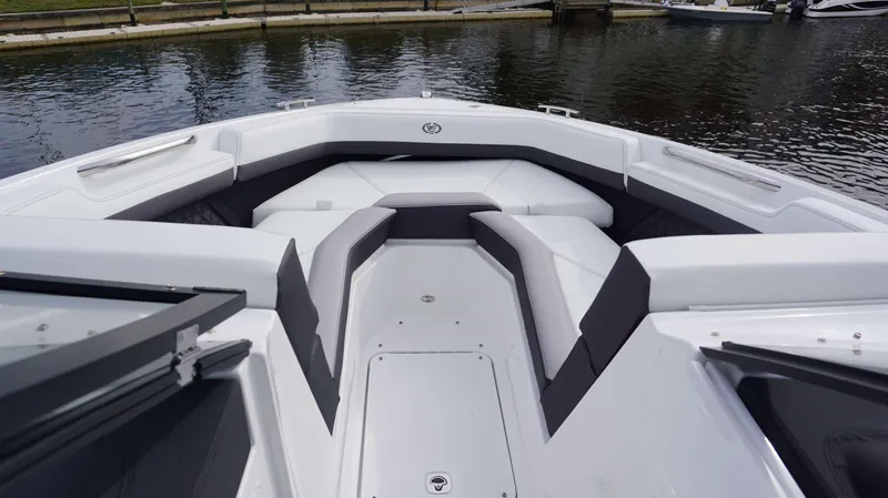 Slide: The Image of 2024 Cobalt R4 boat interior with white and gray seating, docked by the water. - 10