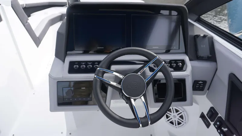 Slide: The Image of 2024 Cobalt R4 boat dashboard with steering wheel and dual Garmin displays. - 4