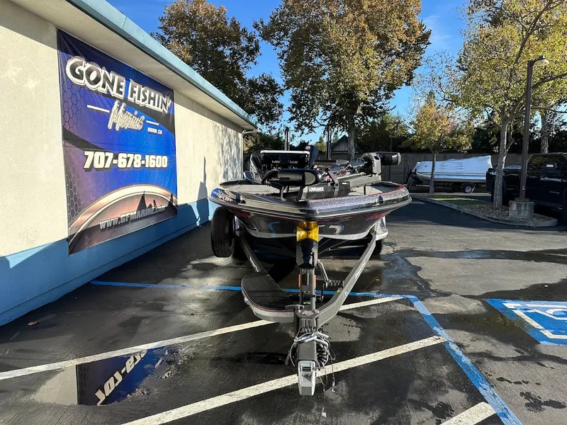 Slide: The Image of 2024 Ranger Z521R boat parked at dealership, sunny day, "Gone Fishin" sign visible. - 1